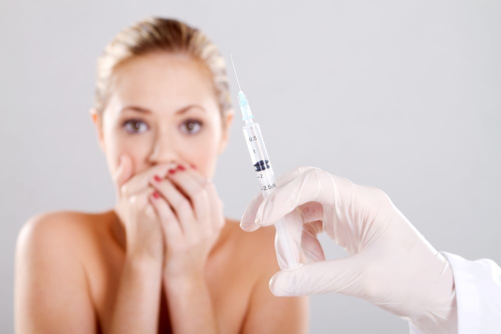 Woman looking afraid of an injection